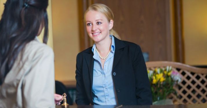 A young employee wearing a suit, talking to her manager about moving up in her career.