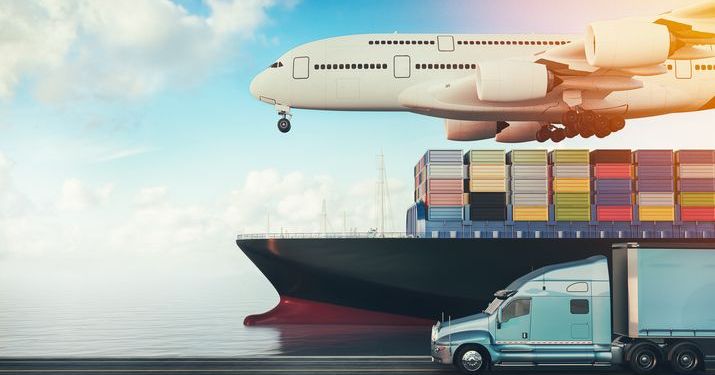 An airplane flying above a cargo ship with shipping containers, while on the ground a light blue semi truck drives next to the ship to illustrate the fundamentals of supply chain.