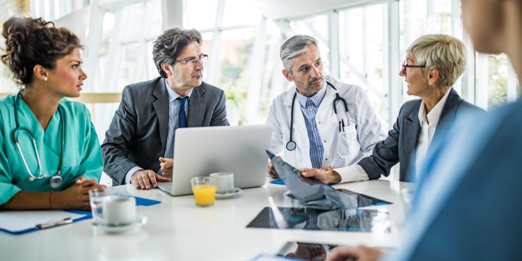 Team of doctors and healthcare managers communicating while having a meeting at doctor's office in the hospital.