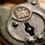 An old, antique lock sitting on top of a wooden table.