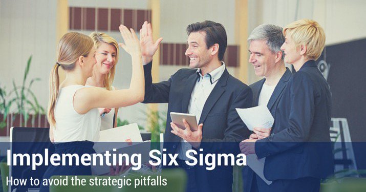 Group of co-workers high-fiving each other after implementing six sigma in the workplace.