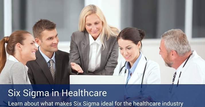 Four healthcare professionals looking at a computer together with a blue banner that reads "six sigma in healthcare".