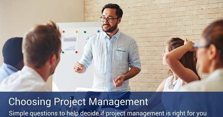 A man giving a presentation about choosing project management to a small group of four co-workers.