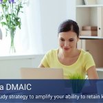 A woman sitting at a desk with a lamp and a cup of pencils working on her laptop, learning about DMAIC.