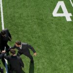 A team of businessmen in suits and ties on a football field in a huddle to represent teamwork.