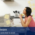 A woman looking up and thinking in her office with post-it notes all over her computer and the wall beside her.