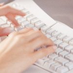 A pair of hands typing on a keyboard.