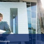 A man holding a bunch of rolled up papers in front of an office.