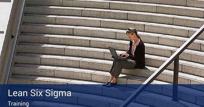 A woman sitting outside on a big flight of concrete steps on her computer. At the bottom of the picture that says "Lean Six Sigma -Training".