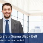 A man in a suit and tie smiling into the camera with a blue banner that says "Becoming a six sigma black belt" on the bottom of the photo.