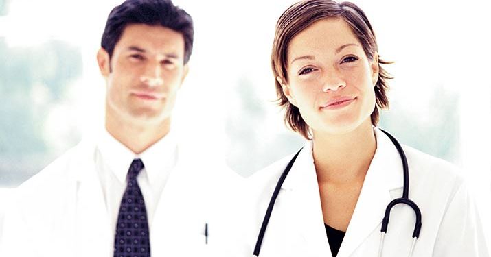 Two medical professionals, one man with a white coat and a black tie and a woman with a white coat and stethoscope around her neck to represent six sigma's impact on the healthcare industry.