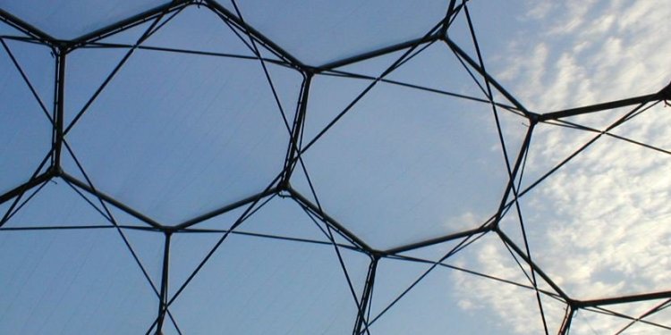 A view looking up at an artsy glass ceiling with hexagon shape patterns.