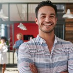 A male data visualization professional smiling in a modern shared workspace