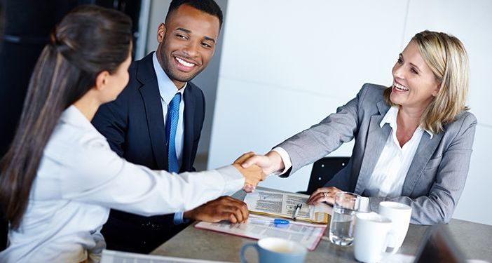 HR Business Partner depicted as a businessman joined by two business women shaking hands across a table.