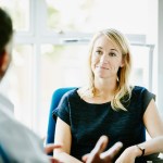 Smiling businesswoman listening to colleague