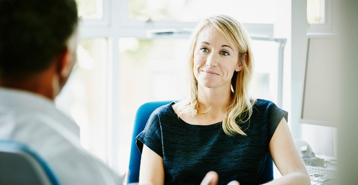 Smiling businesswoman listening to colleague