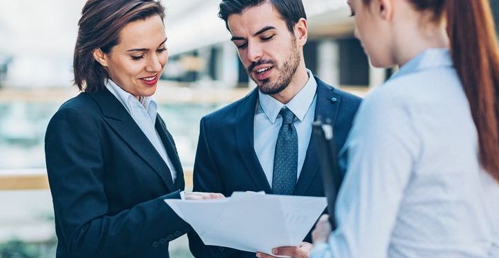 Office workers discussing the stipulations of a document