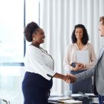 A hiring manager shakes the hand of a new employee.