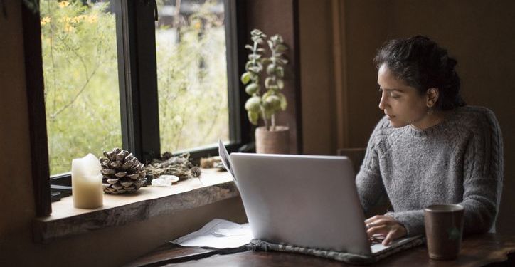 Mixed-race businesswoman works at home on computer