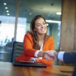 Confident professional shakes hands with hiring manager in a job interview