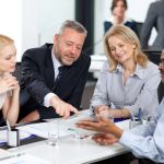 Team leader discusses a project with their team in an office.