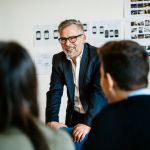 Mature businessman speaking during an informal meeting to younger colleagues