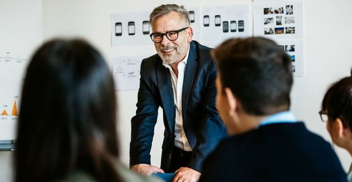 Mature businessman speaking during an informal meeting to younger colleagues