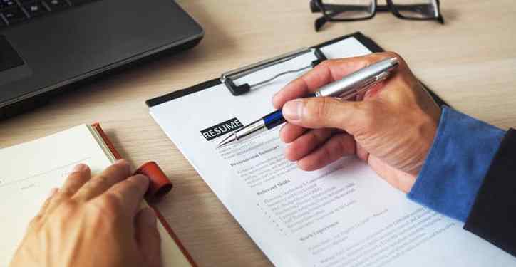 Man writing a resume in an office.