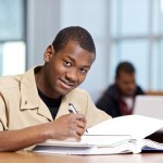 Military student in beige uniform smiling while studying