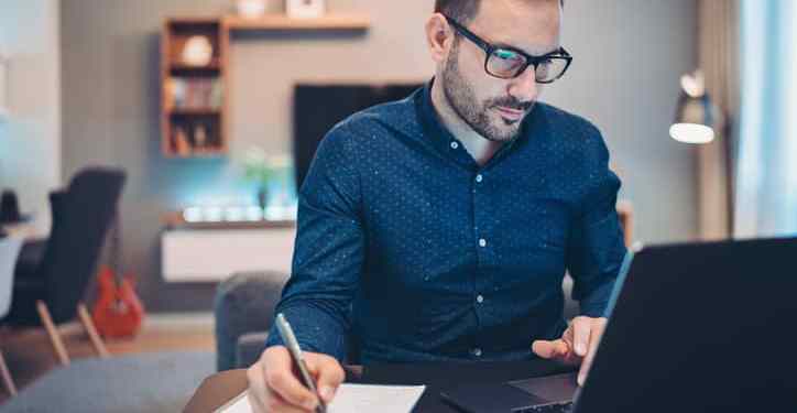 Businessman using laptop and doing paperwork at home